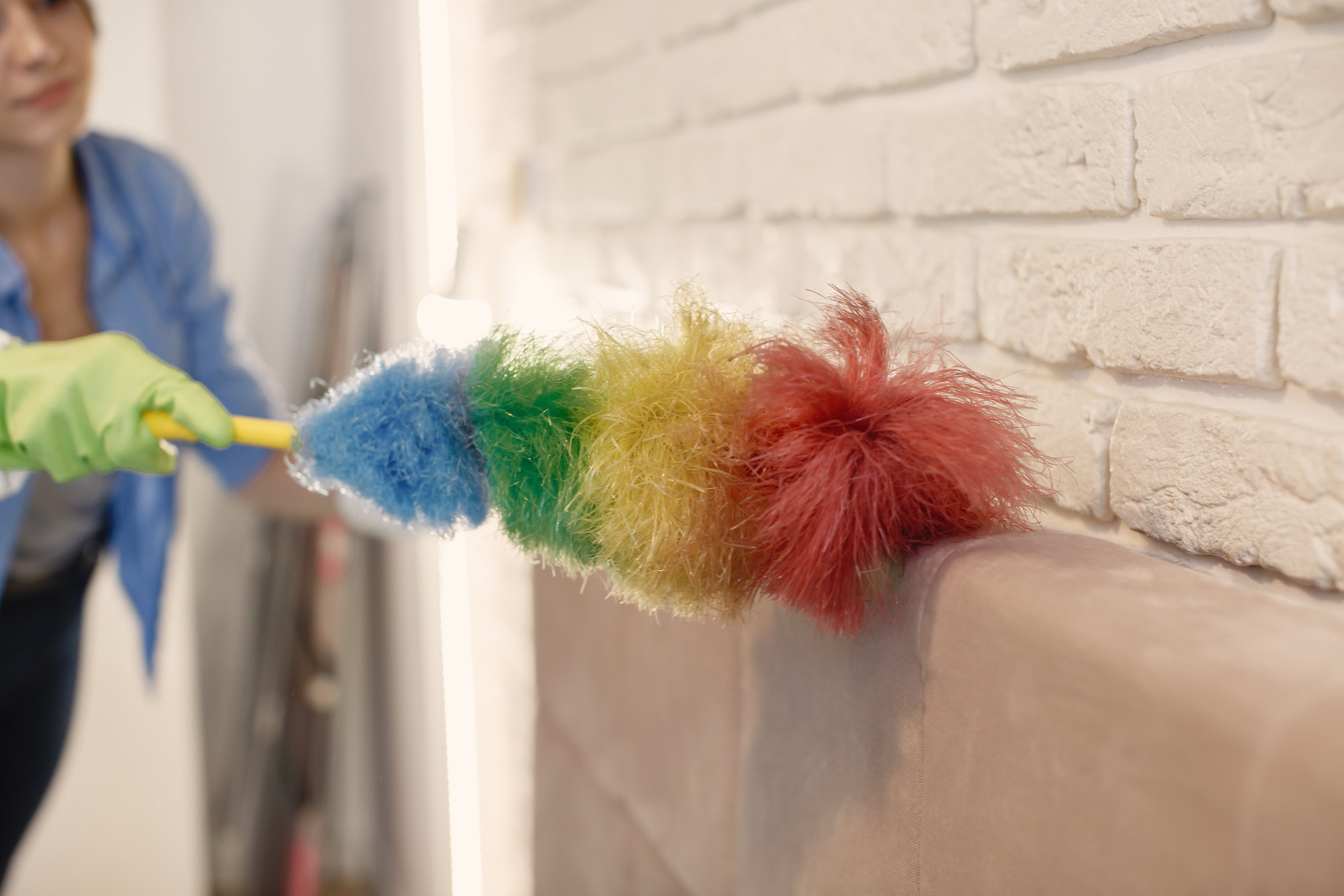 Woman with sponge and rubber gloves cleaning house